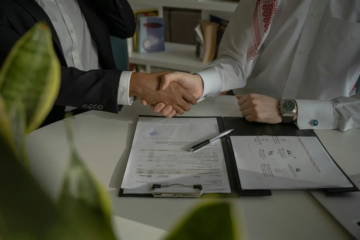 Business professionals shaking hands after a successful mergers and acquisitions agreement